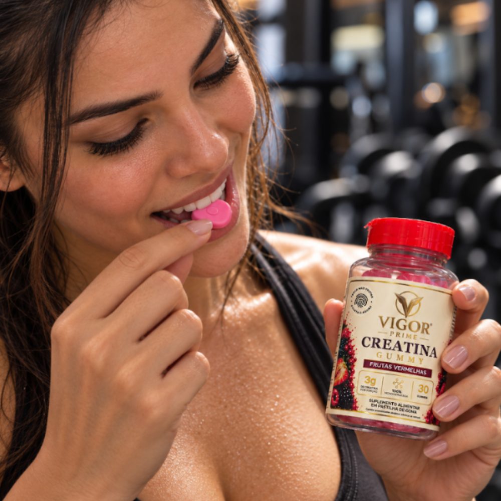 Mulher na academia comendo uma goma Vigor Prime, com o pote ao lado